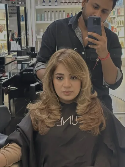 A mirror selfie showing the full effect of this blonde transformation. The layers and color work together to create a stunning, glamorous look.