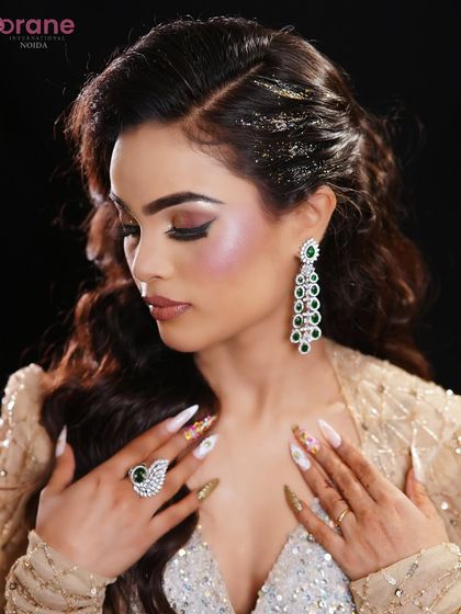A close-up that showcases the beautiful nail art, the emerald green jewelry, and the perfectly blended eyeshadow.