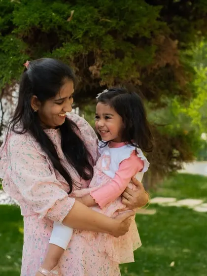 A candid moment of laughter between a mother and daughter in the park. These genuine expressions are what make a portrait truly come to life.