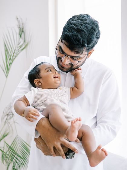 A father holding his smiling baby. The happiness in this simple moment is what I love to capture.