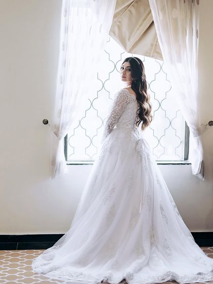 A classic bridal portrait by the window, using natural light to create a timeless and elegant photograph.