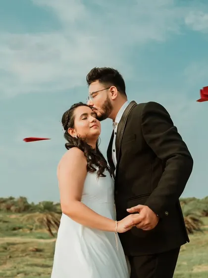 A whimsical and creative pre-wedding photo featuring a couple with red paper airplanes flying around them. This conceptual shot adds a touch of playfulness and imagination to their love story.