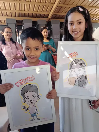 These siblings are all smiles with their framed caricatures. It's a unique way to capture their childhood personalities.
