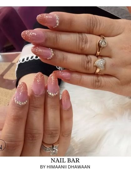 A beautiful ombré glitter design with a nude base fading into a sparkling tip, accented with small pearls.