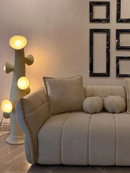 Comfort meets sculptural beauty in this flange-trim bouclé sofa. The soft, organic shape, squishy cushions, and textured fabric create a perfect spot to relax, proving that modern design can be incredibly snug and inviting.