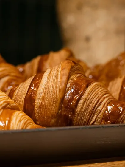 A tray of fresh, golden croissants in Paris. This image is perfect for a bakery, conveying authenticity and high quality.