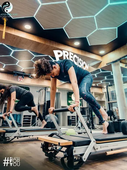 Precision is key in Pilates. These clients are performing a mountain climber variation on the reformer, focusing on precise, controlled movements to maximize core engagement.