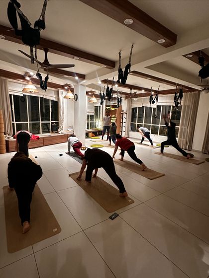 A class practices a lunge variation, the low lighting creating a focused and intimate atmosphere.