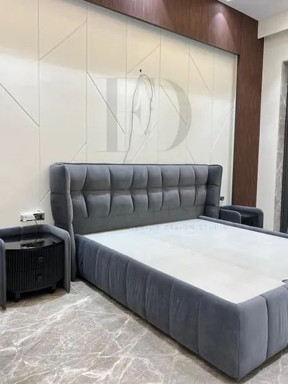 This modern bed features a tufted, winged headboard in a sophisticated grey velvet. The front-lift hydraulic mechanism reveals ample under-bed storage, combining luxury with practical functionality.