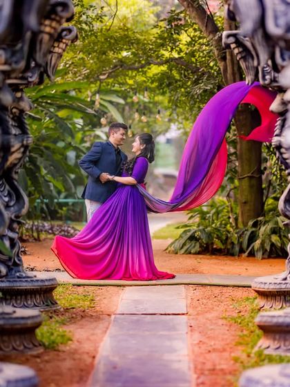 A creative shot framing a couple in a flowing gown between ornate stone pillars, adding a sense of depth and artistry.