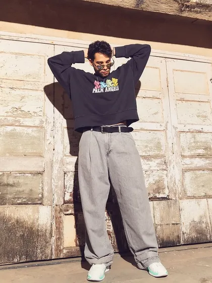 Kicking off the HT Brunch editorial with Siddhant Chaturvedi. This look is all about modern streetwear, pairing a Palm Angels sweatshirt with baggy pinstripe trousers for an urban, relaxed feel.