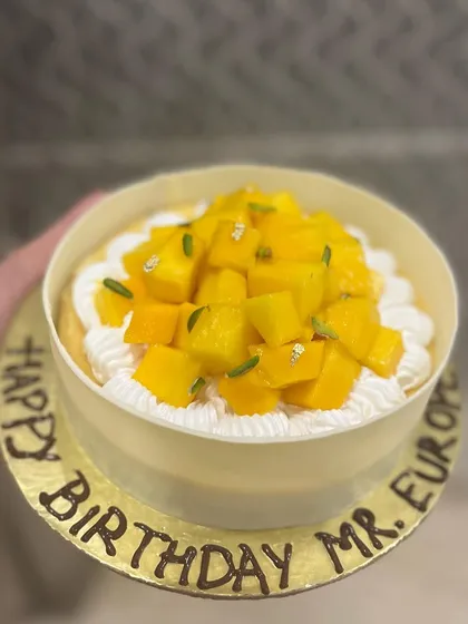 A beautiful Mango and Vanilla Bean Baked Cheesecake, topped with fresh mangoes and pistachios. It's the perfect blend of creamy and fruity.