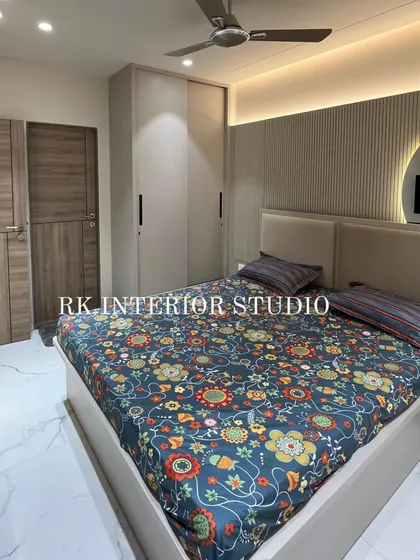 This angle showcases the full bedroom layout, including the bed, wardrobe, and TV unit. The consistent color and material palette creates a cohesive and calming space.