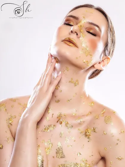 An artistic beauty portrait of a model with eyes closed, adorned with gold leaf. This demonstrates our skill in creating serene and ethereal moods for editorial and conceptual projects.