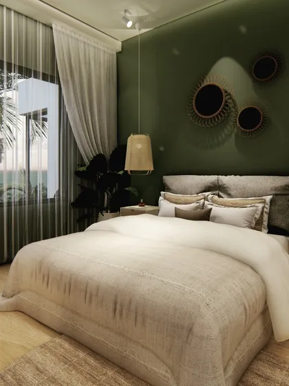We used a deep olive green for the accent wall in this bedroom to create a cozy and intimate feel. Rattan pendant lights and wooden furniture add a natural, bohemian touch, complemented by the view of palm trees outside.