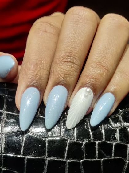 A simple yet stunning 3D look. This set features glossy baby blue almond nails with a white accent nail sculpted into a 3D shell texture, adorned with tiny pearls.