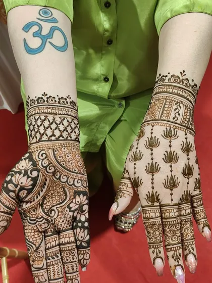A beautiful example of two different styles for a client. One hand features a dense floral and paisley pattern, while the other has a neat grid of lotus motifs.