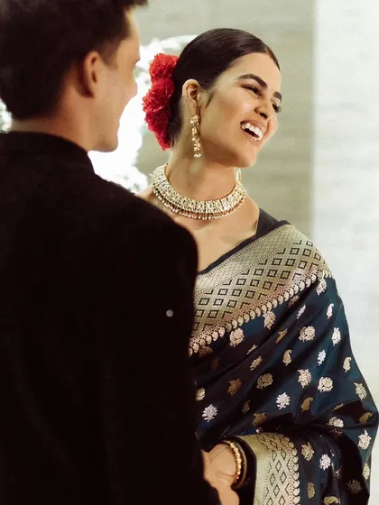 The bride's face lights up with a genuine, beautiful laugh. This candid shot, taken over the groom's shoulder, captures a moment of pure happiness and connection between them.