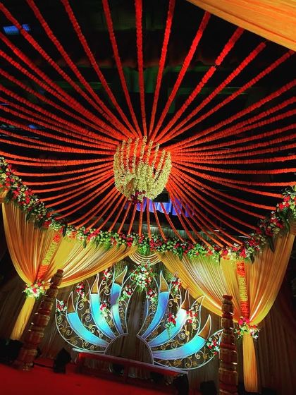 A view from inside the mandap, looking up at the ceiling decor. I used strings of red flowers radiating from a central floral chandelier, creating a stunning sunburst effect that adds drama and detail to the sacred space.
