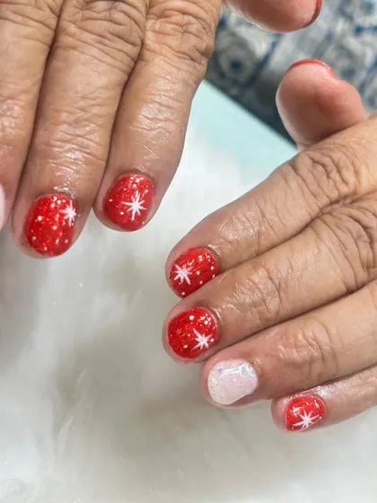 Getting into the Christmas spirit with this cute and festive design. I used a sparkly red base with hand-painted white stars, paired with a shimmering white accent nail for a classic holiday look.