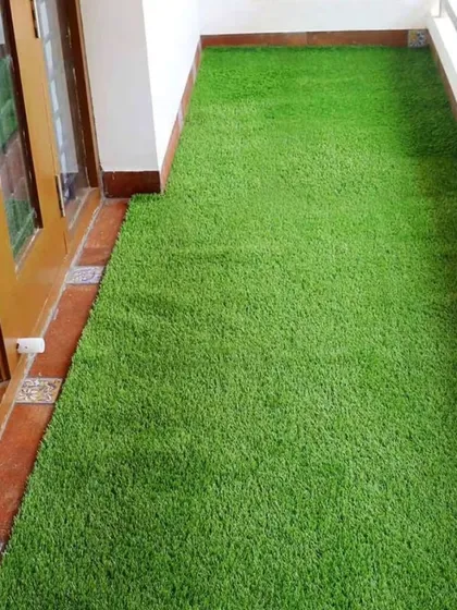 A narrow balcony transformed with a lush green artificial grass mat. It's a simple, clean, and effective way to improve any small outdoor space.