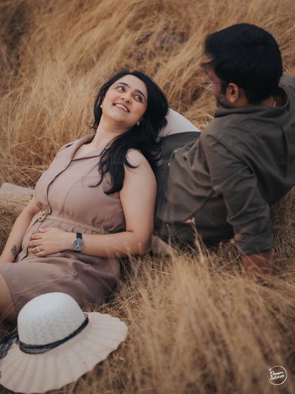 A candid shot of a couple sharing a look of love amidst tall, golden grass. The natural setting and warm tones make this a beautifully rustic and romantic portrait from their Lonavala pre-wedding session.