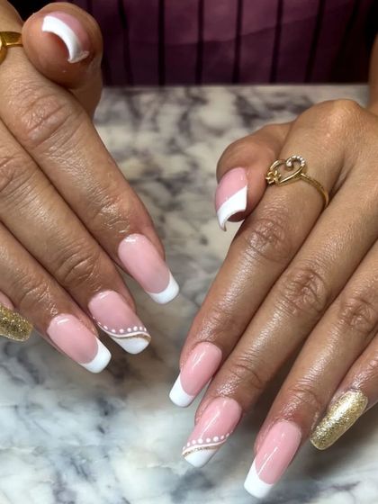 The full view of the elegant French manicure with gold glitter accents. It's a glamorous and sophisticated look, perfect for a special occasion.