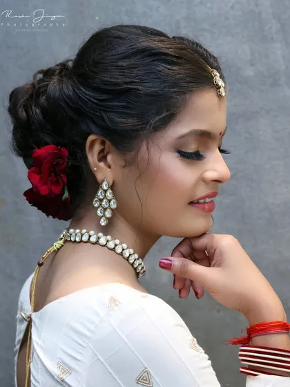 A classic pose showing the side profile, with a focus on the elegant updo and the soft makeup.