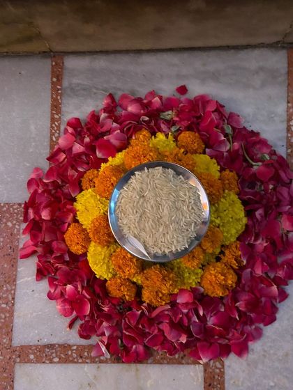 For some ceremonies, a bowl of rice is used as part of the welcome ritual. I can incorporate this into the floral arrangement, as shown here with a thali of rice set within a bed of marigolds and rose petals.