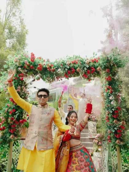The Haldi ceremony is pure, unadulterated joy. Here, the couple makes a grand entrance through a floral arch, surrounded by friends, dhol beats, and a riot of color bombs. It's these moments of high energy and infectious laughter that I love to capture.