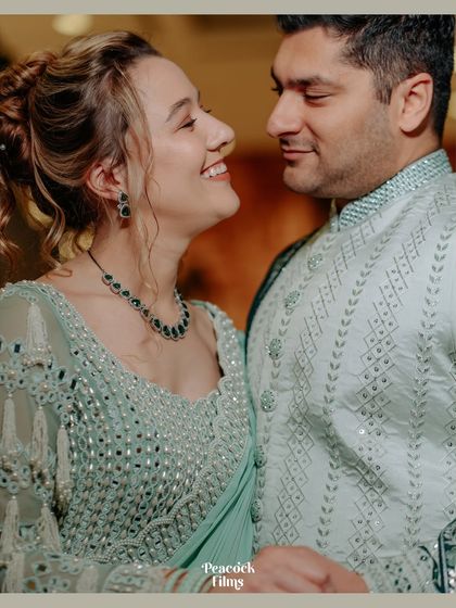 A close-up of the couple, their faces close together, sharing a happy and intimate moment during their cocktail party.
