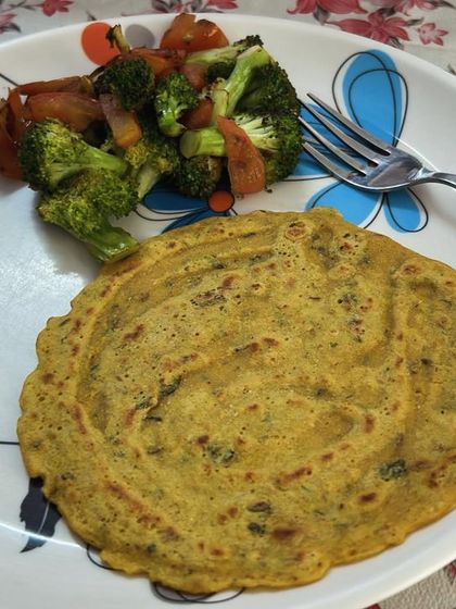 A plate of besan cheela with a side of stir-fried broccoli and carrots. A perfect protein and fiber-rich meal.