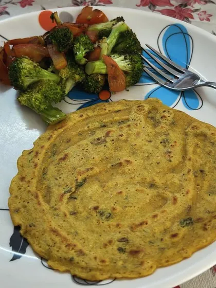 A plate of besan cheela with a side of stir-fried broccoli and carrots. A perfect protein and fiber-rich meal.