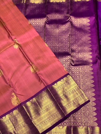 A close-up of the rich zari work on the pallu of the pink Kanchipuram silk saree.