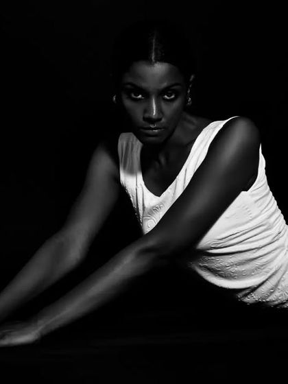 A dynamic, full-body pose in black and white, creating a sense of movement and length.