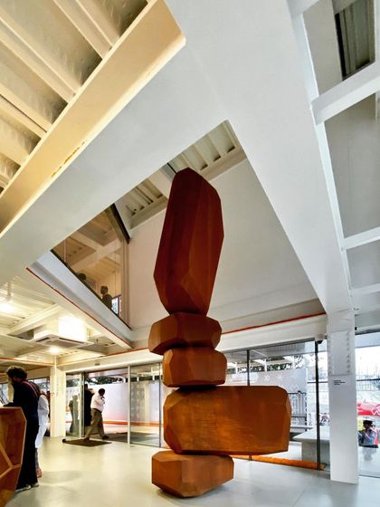 The main lobby of the Museum of Art and Photography (MAP), showing the relationship between the reception area, the large central sculpture, and the upper-level walkways. The space is designed to be open, welcoming, and easy to navigate.