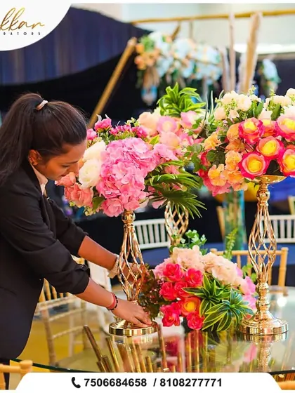A member of my team carefully arranging a floral centerpiece. I ensure every single detail is perfect, from the placement of each flower to the final look of the table.