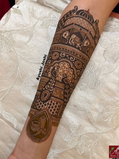 A close-up of the arm from the no-figure bridal design, showing the detail in the peacock and elephant motifs.