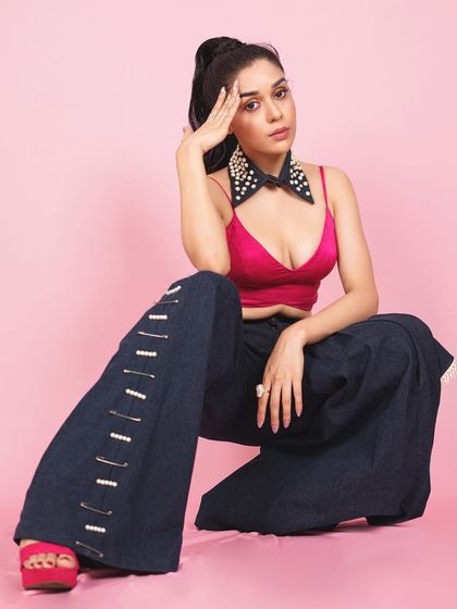 A powerful squatting pose from Eisha, adding an edgy and confident vibe to the colorful and playful fashion shoot.