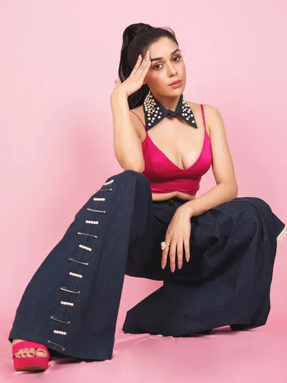 A powerful squatting pose from Eisha, adding an edgy and confident vibe to the colorful and playful fashion shoot.