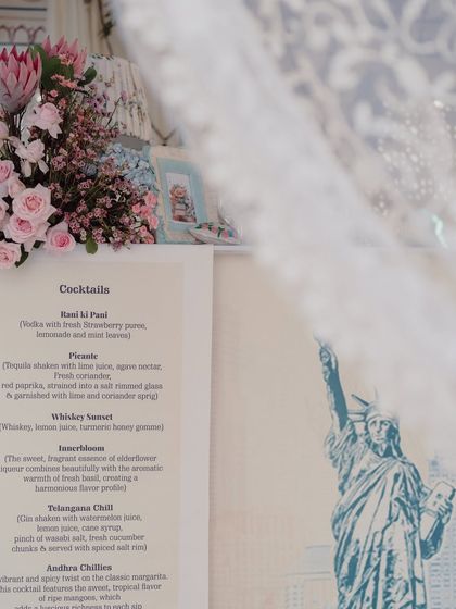 A close-up of the cocktail menu, with a hint of the New York skyline in the background, telling the couple's story.