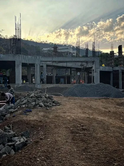 The concrete frame of a house rises against the evening sky. This image captures the raw power and potential of a project in its early stages, a skeleton waiting to be fleshed out with materials and life.