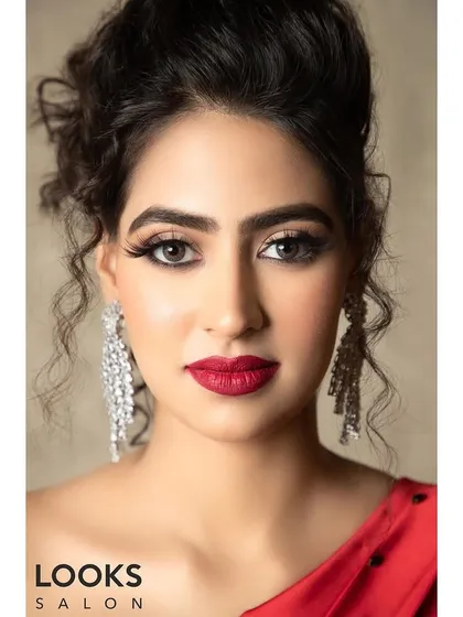 A direct, confident portrait of the red dress look. The matte red lipstick is the hero here, perfectly applied to create a powerful and glamorous statement.