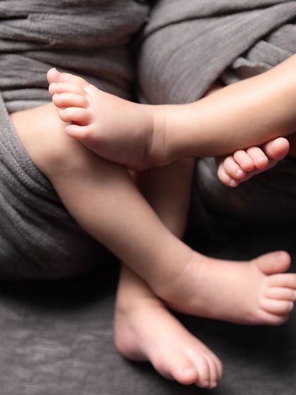 It's all in the tiny details. This close-up of four little feet tells a story of a shared journey, from the womb to the world.