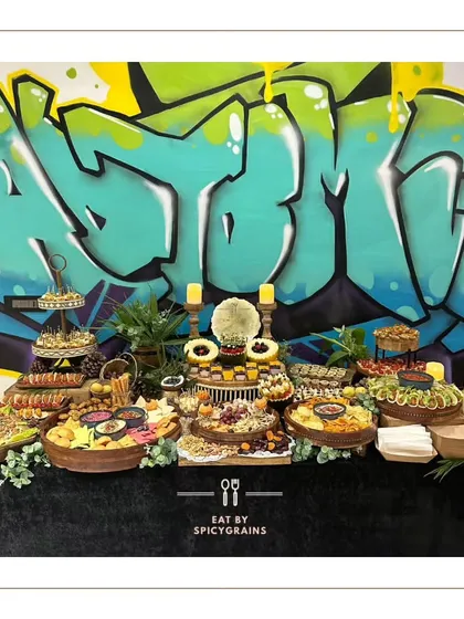 This grazing table, set against a bold graffiti wall, shows how we can adapt our style to any venue. The contrast between the urban art and our elegant food setup created a unique and memorable visual for the event.