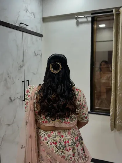 A classic half-updo with a decorative clip, a versatile style for any wedding guest.