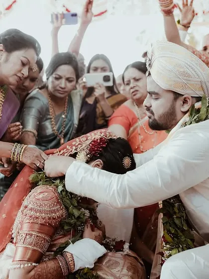 Family members join in to bless the couple during a key wedding ritual. This photo is all about the involvement of loved ones, showing a moment of community and tradition.