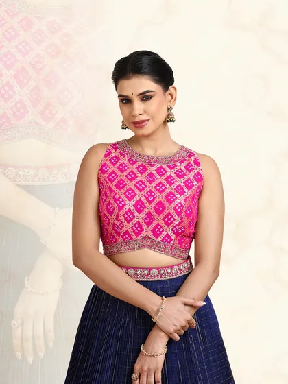 A close-up of the pink embroidered blouse, featuring a geometric pattern and a modern cut-out design.