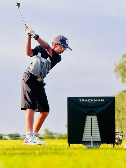 A young athlete fully engaged in a TrackMan session. By introducing this technology early, we instill a data-driven mindset and teach our players how to use feedback to guide their practice.