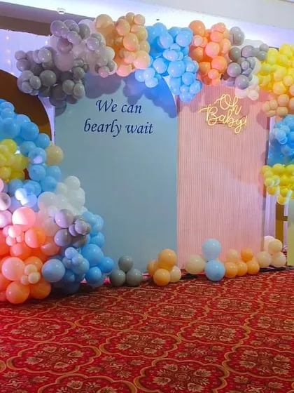 A colorful "We Can Bearly Wait" baby shower setup with a multi-colored balloon arrangement, perfect for a gender-neutral celebration.
